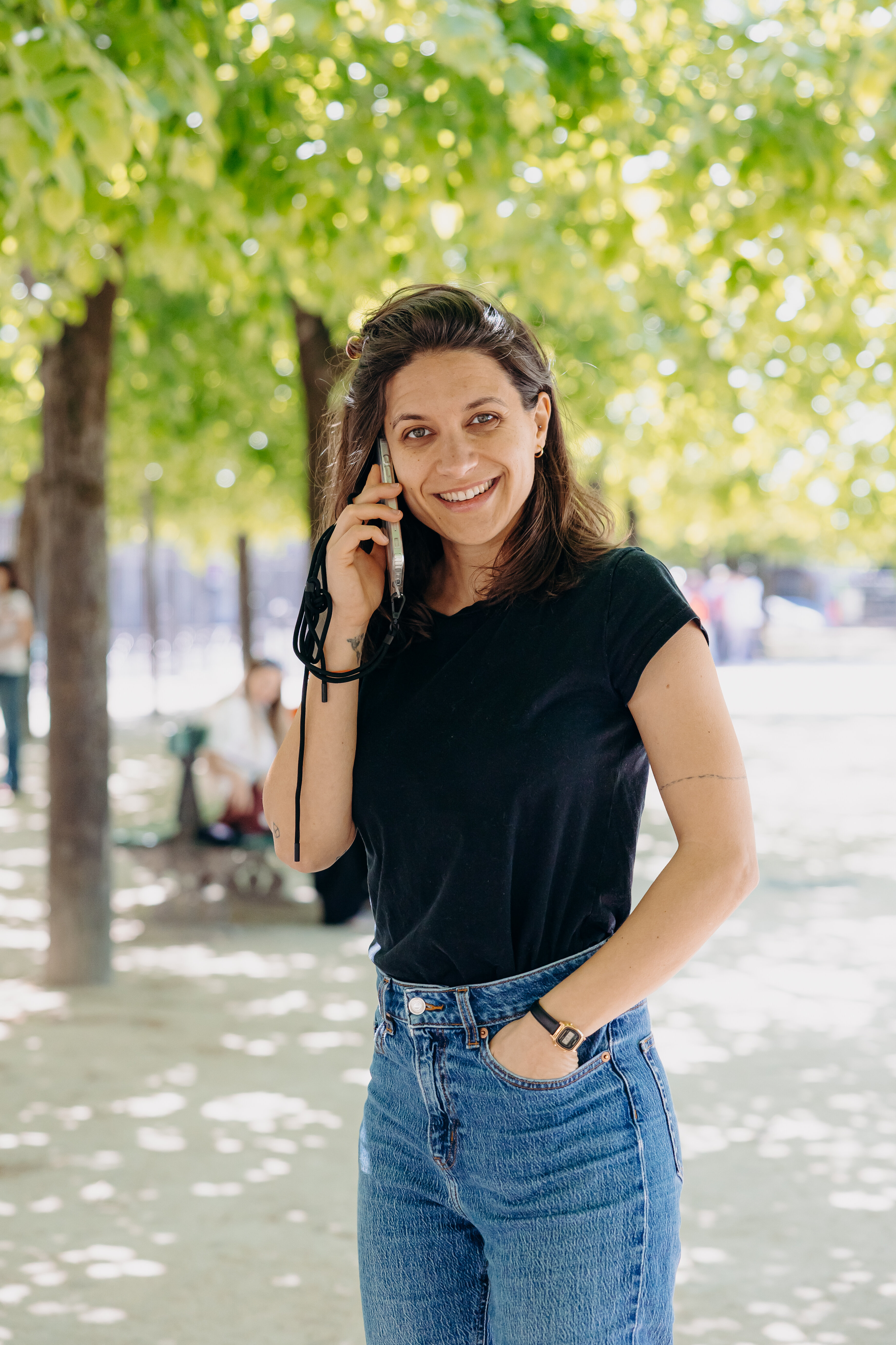 Sarah Segala au téléphone sous les arbres